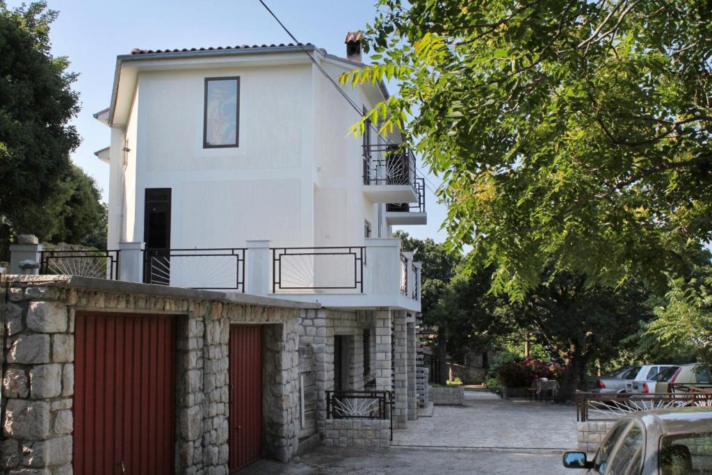 a white house with a red garage at Apartments by the sea Klenovica, Novi Vinodolski - 5580 in Klenovica