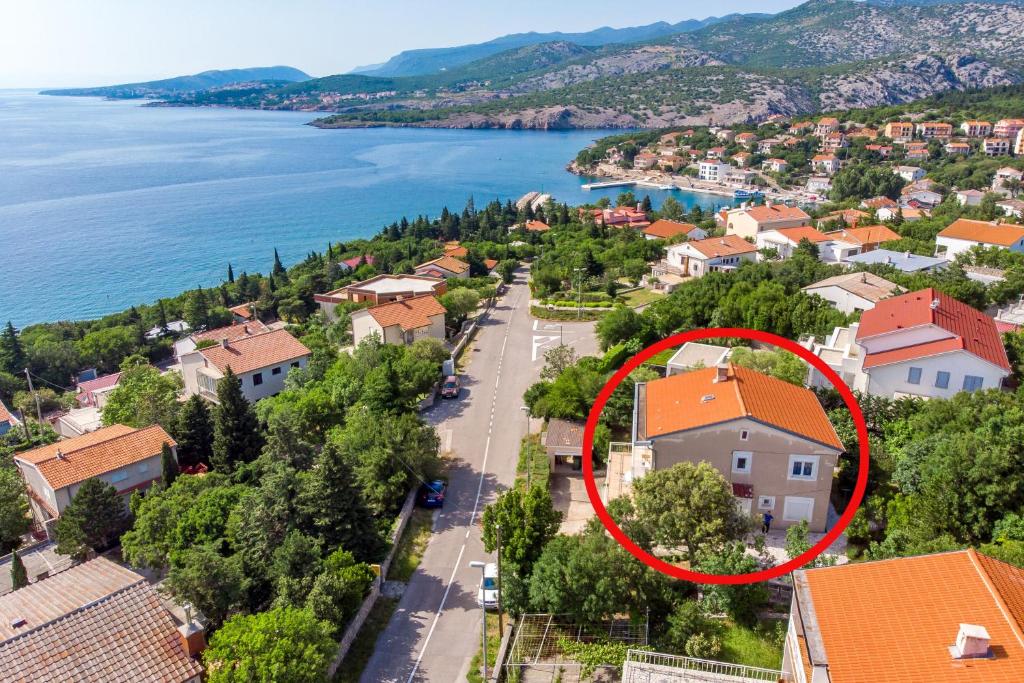 a house with a red roof in a town next to the water at Apartments by the sea Klenovica, Novi Vinodolski - 5575 in Klenovica