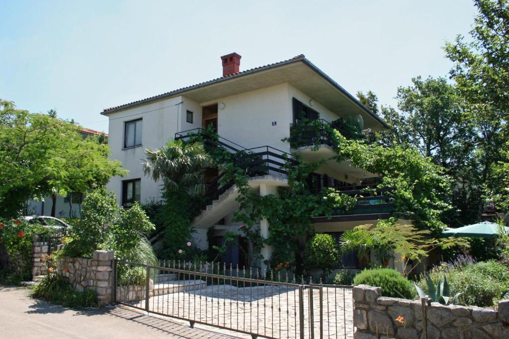 una casa blanca con una valla delante en Apartments with a parking space Jadranovo, Crikvenica - 5533, en Jadranovo