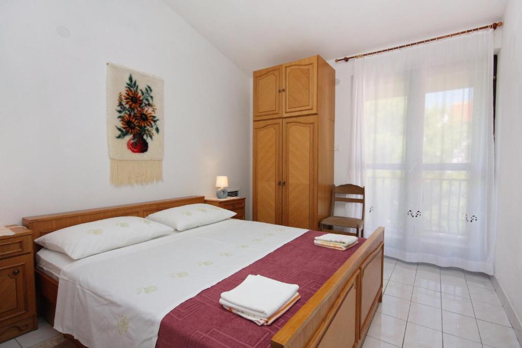 a bedroom with a bed and a wooden cabinet at Apartments with parking space Supetar, Brac - 5653 in Supetar