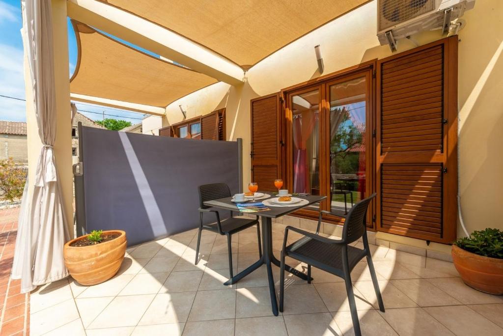 a patio with a table and chairs on a balcony at Studio Nin 5666b in Nin