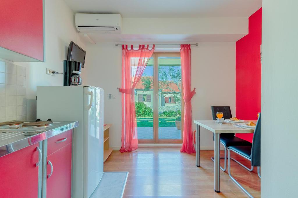 a kitchen with red walls and a table and a window at Studio Nin 5666b in Nin