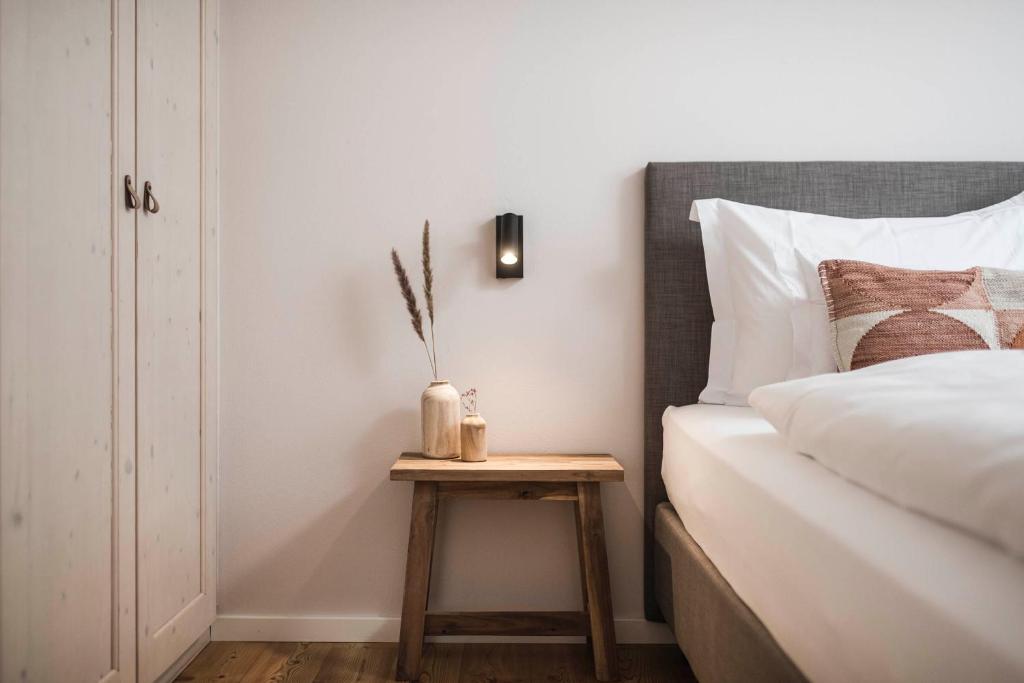 um quarto com uma cama e uma mesa de cabeceira ao lado de uma mesa lateral em apartments55 em Bressanone