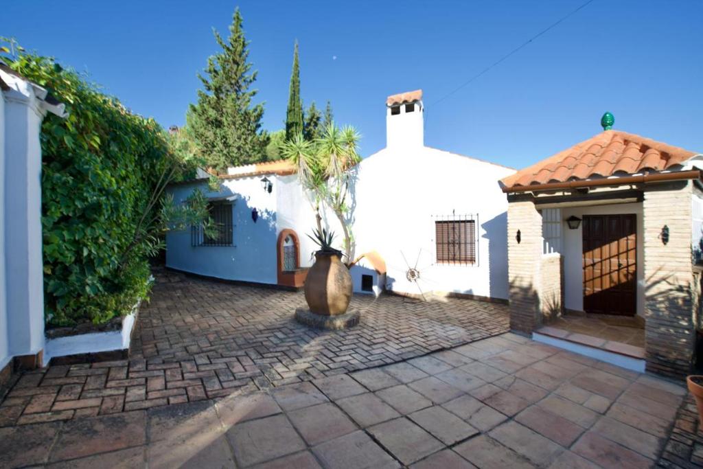 un patio de una casa blanca con una maceta en CASA RURAL SANTA ELENA, en Cazalla de la Sierra