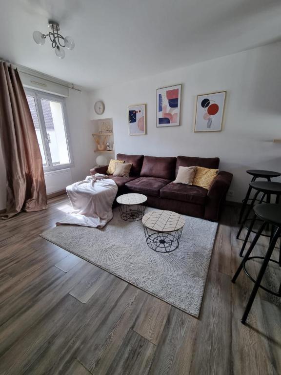 uma sala de estar com um sofá e duas mesas em Duplex 40m2 cocooning cœur de ville avec parking em Neauphle-le-Château