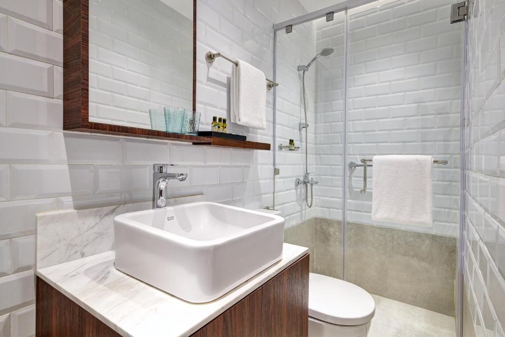 a white bathroom with a sink and a shower at Aerotel Cebu in Mactan