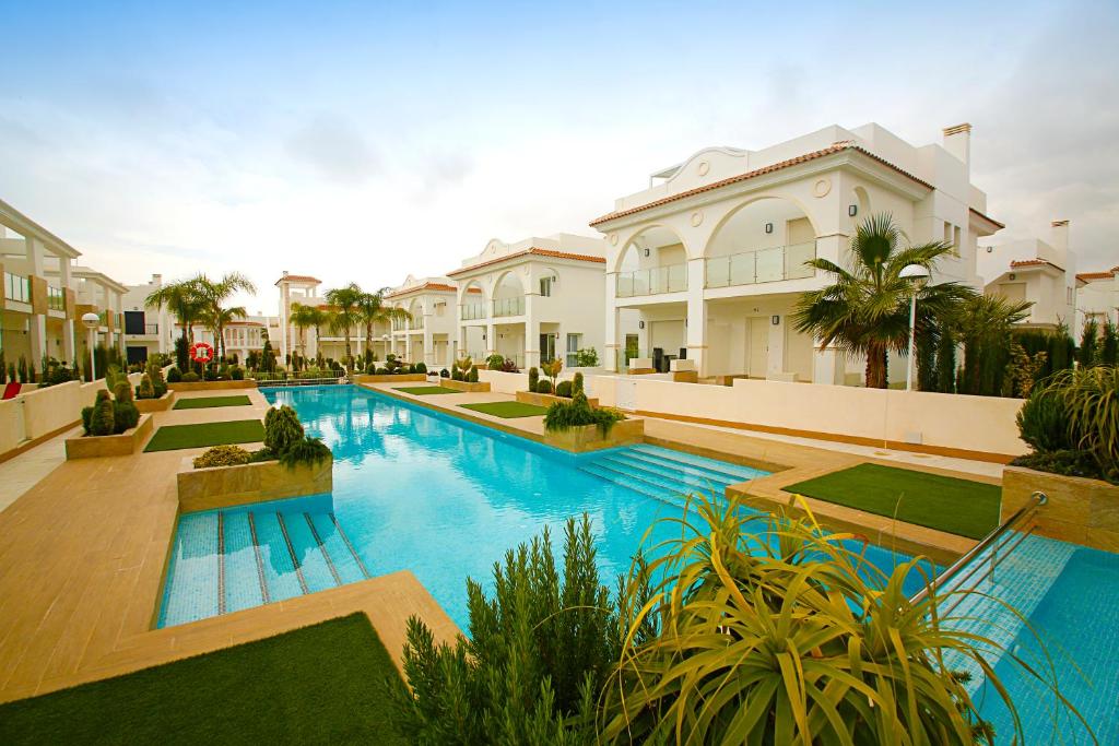 a large swimming pool in front of a house at Luxury bungalow Allegra 43 with AC and Pool in Ciudad Quesada