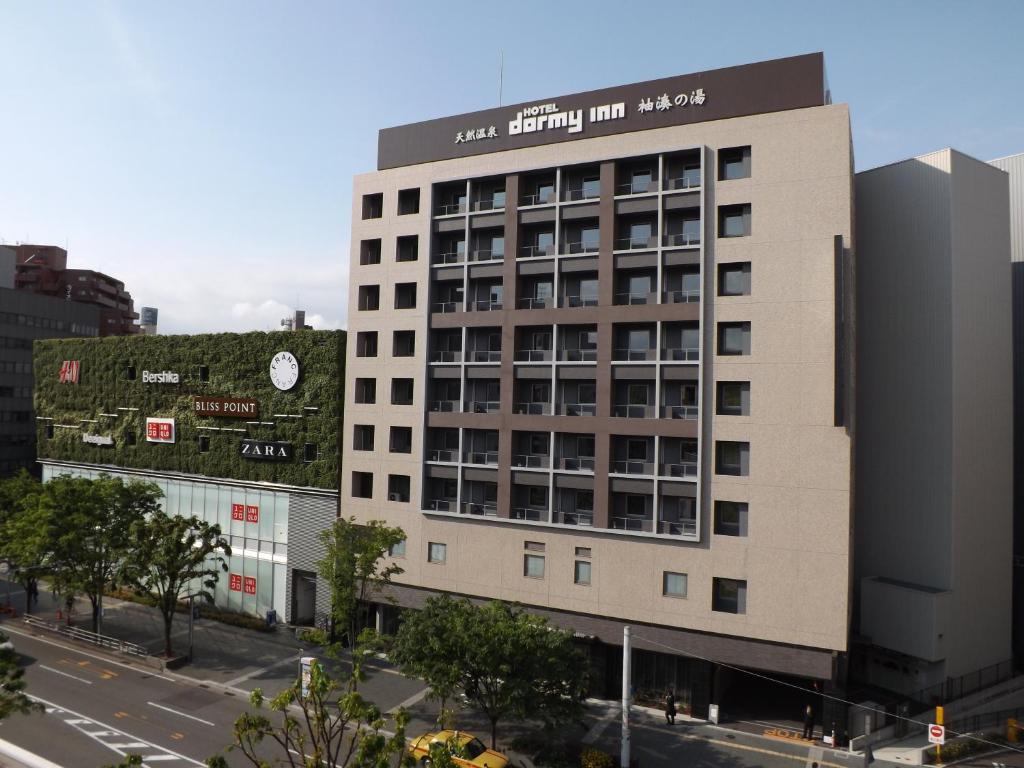 un edificio blanco alto con un letrero. en Dormy Inn Premium Hakata Canal City Mae, en Fukuoka