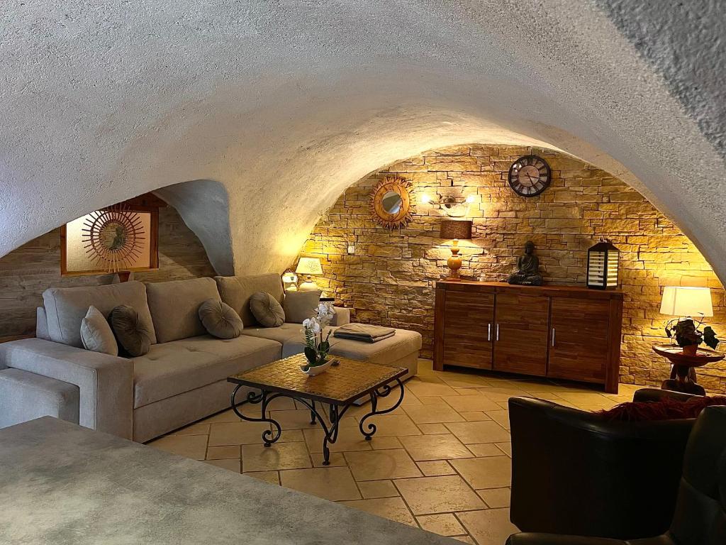 a living room with a couch and a stone wall at La Belle Escale in Gap