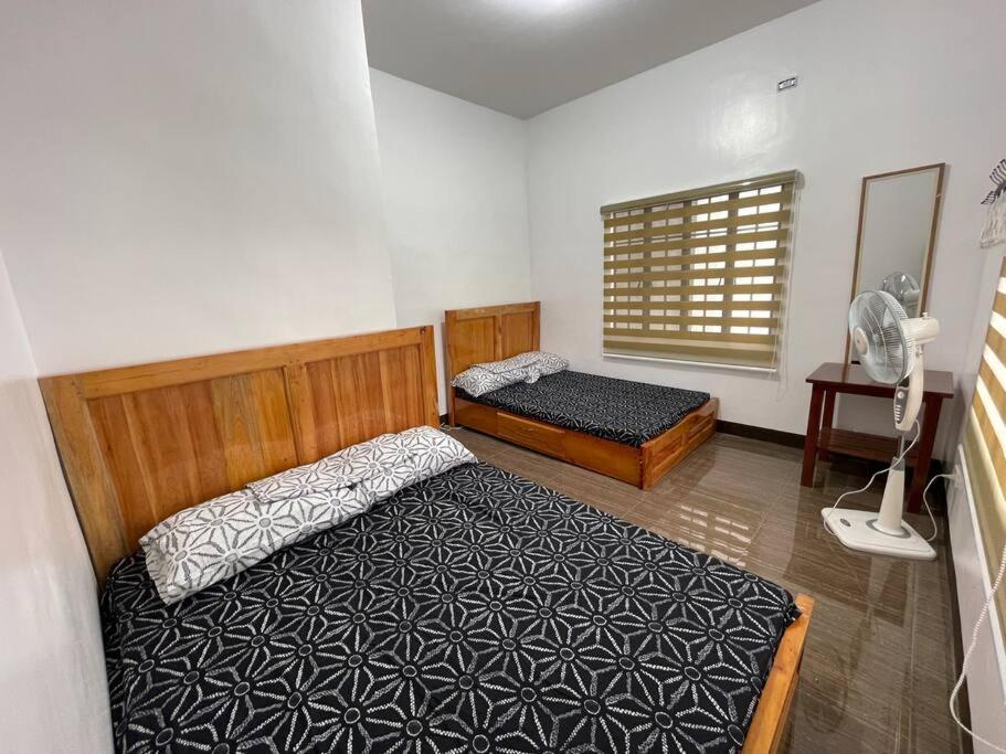 a bedroom with two beds and a fan at Tagaytay Transient House, 4 bedrooms, billiard in Indang
