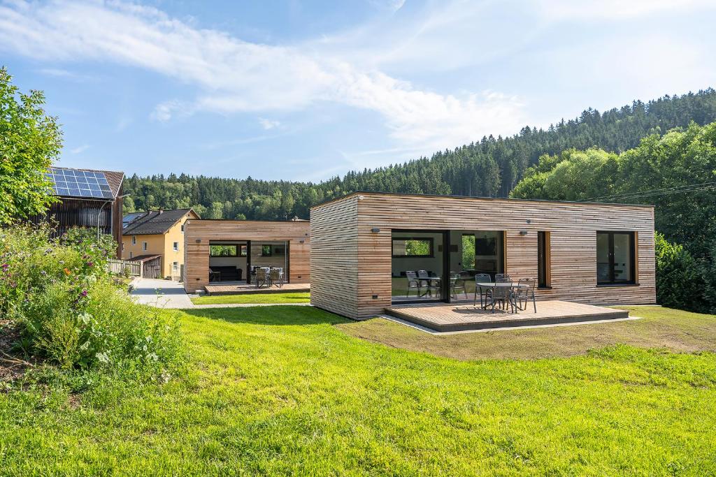 a small wooden house with a patio in a yard at Modul Häuser Maurer in Georgenberg