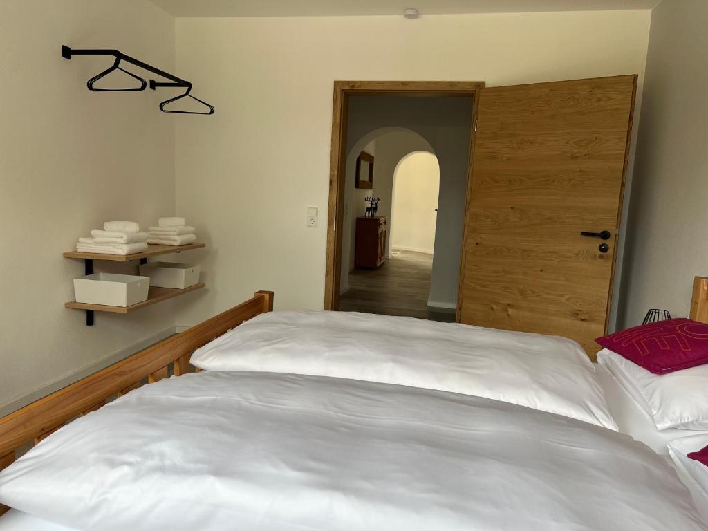 um quarto com uma grande cama branca e uma porta em Ferienwohnung Kohl - Malerhäusl - Berchtesgaden em Berchtesgaden