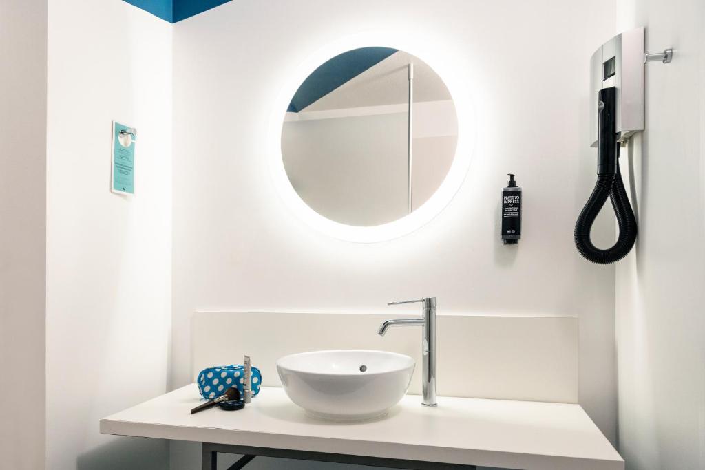 a white bathroom with a sink and a mirror at ibis Styles Toulon Centre Port in Toulon