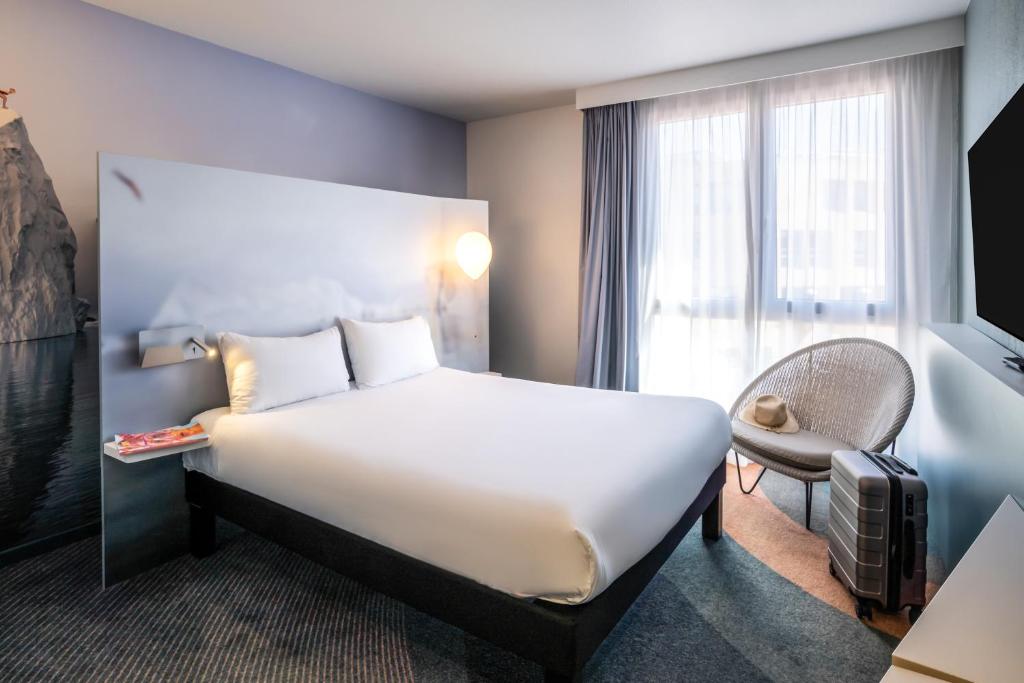 a hotel room with a large bed and a window at ibis Styles Toulon Centre Port in Toulon