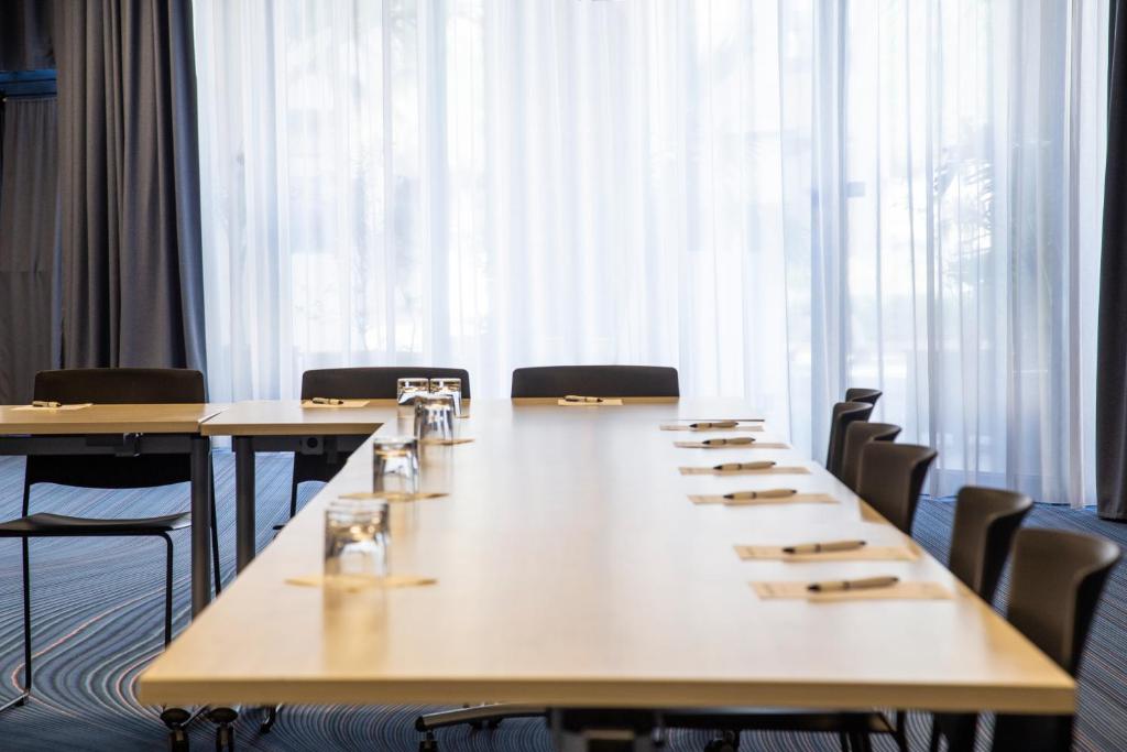 a conference room with tables and chairs and a large window at ibis Styles Toulon Centre Port in Toulon