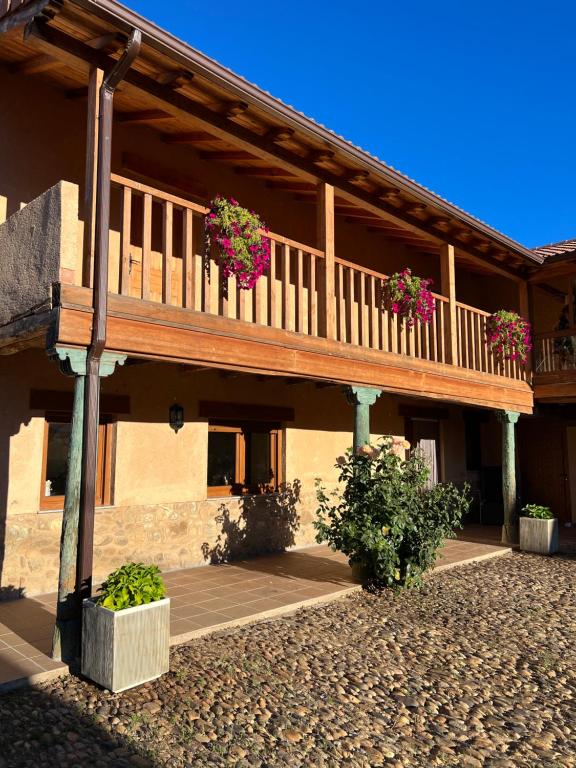a building with a balcony with flowers on it at Casa Villa Franca in Llamas de la Ribera