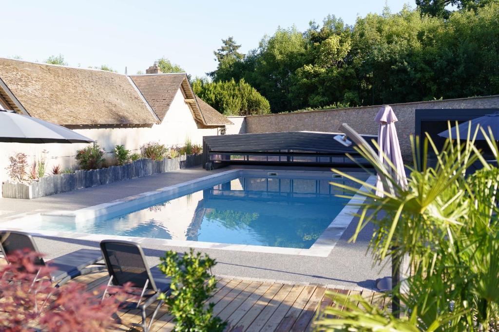 a swimming pool in the backyard of a house at LE LODGE DU DOMAINE in Saint-Hilaire-en-Morvan