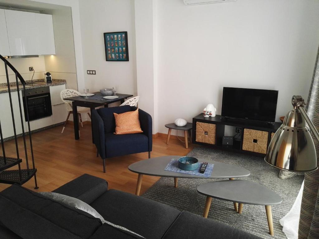 uma sala de estar com um sofá e uma mesa em Apartamento Cervantes em Málaga