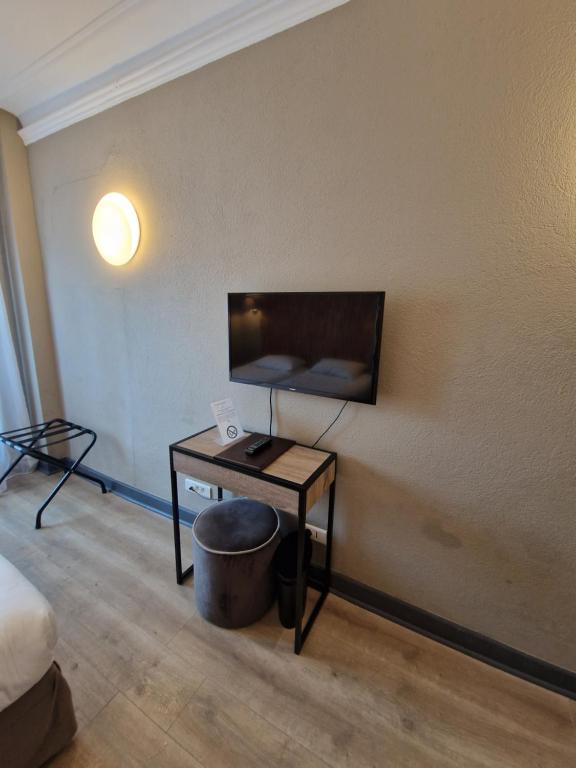 a room with a desk and a tv on a wall at Hôtel La Villa Tosca in Cannes