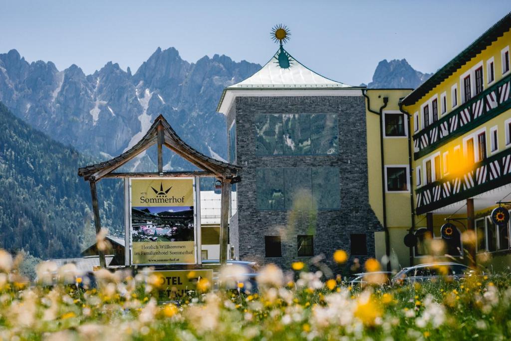 una señal frente a un edificio con montañas en el fondo en Hotel Sommerhof, en Gosau