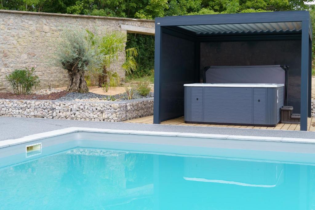 a swimming pool with a hot tub in a garage at LE LODGE DU DOMAINE in Saint-Hilaire-en-Morvan