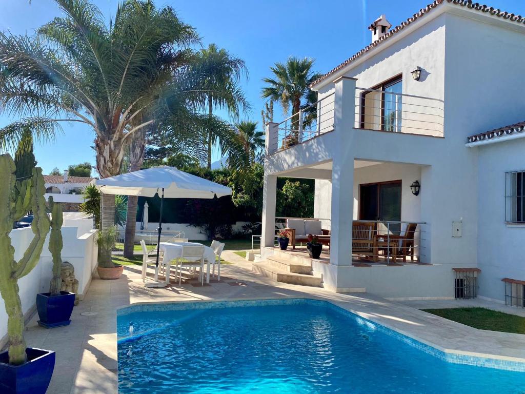 a villa with a swimming pool in front of a house at Luxury Villa with Pool in Marbella