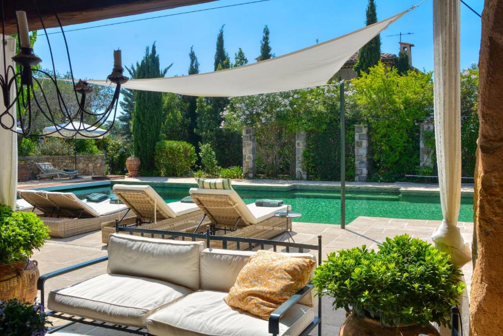 un patio con sillas y una piscina en La Maison de Platane B&B, en Fayence