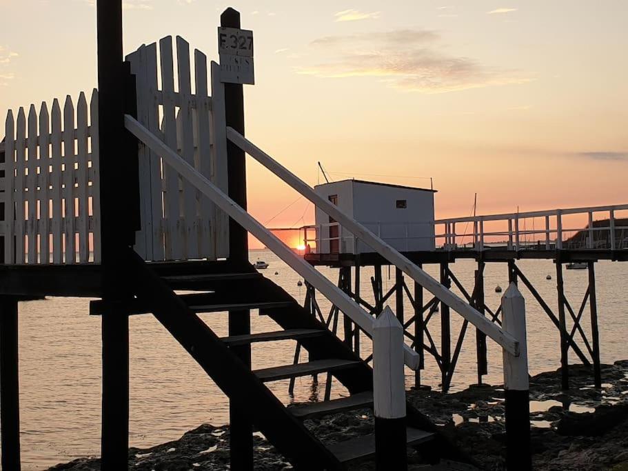 un banco sentado en la playa cerca de un muelle en Le petit paradis en bord de mer Fouras les Bains, en Fouras