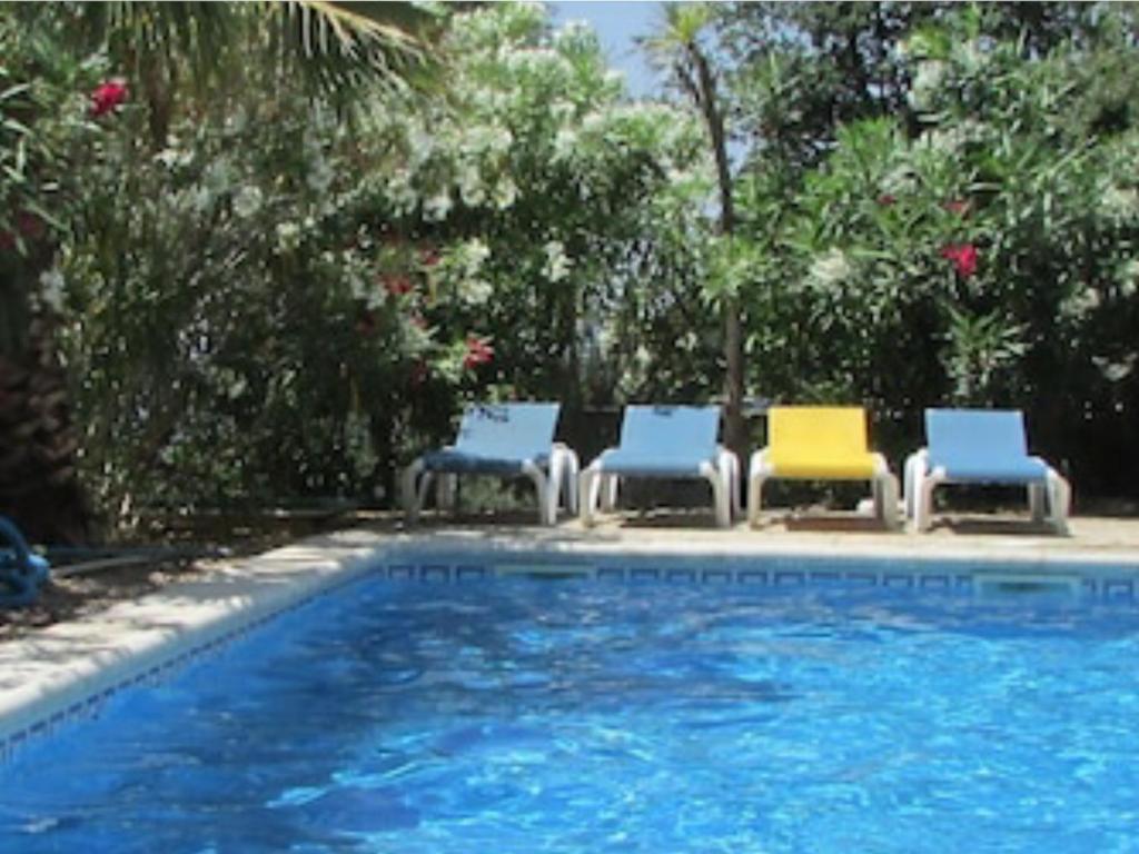 a group of chairs sitting next to a swimming pool at Cosy apartment with private swimming pool in Santa Cristina d'Aro