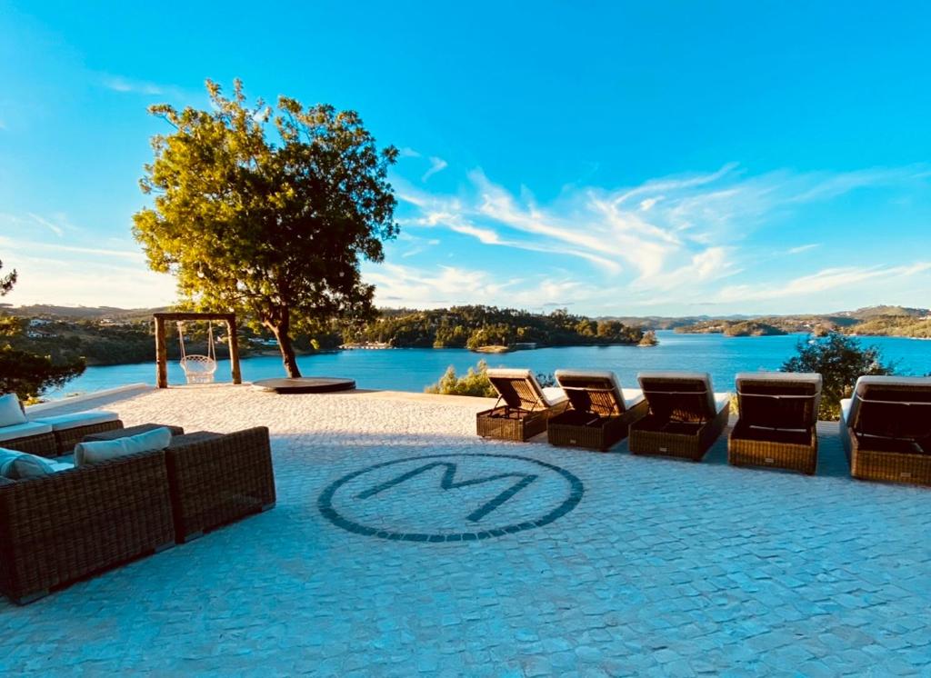 a patio with chairs and a view of a lake at Marti Watersports in Martinchel