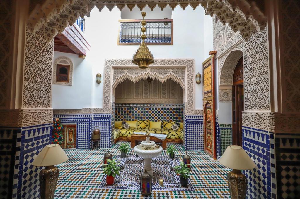 sala de estar con azulejos azules y blancos y sofá en Dar Hafsa en Fez