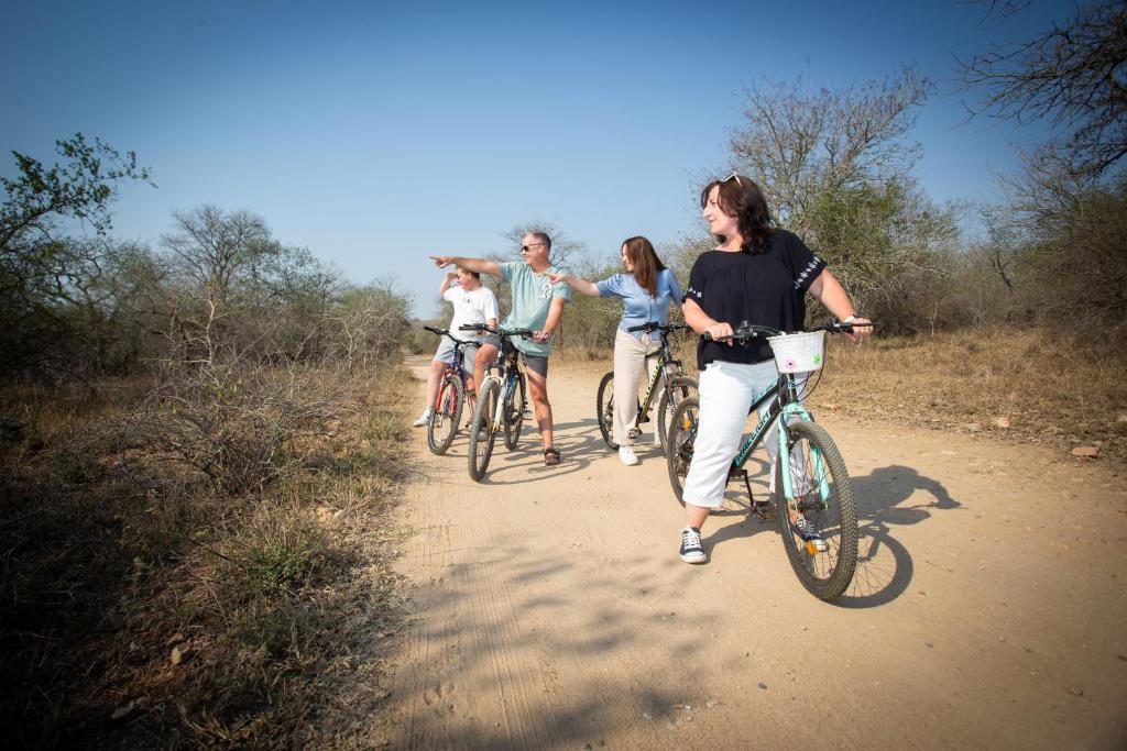 a group of people riding bikes down a dirt road at Doringpoort Lodge in Marloth Park