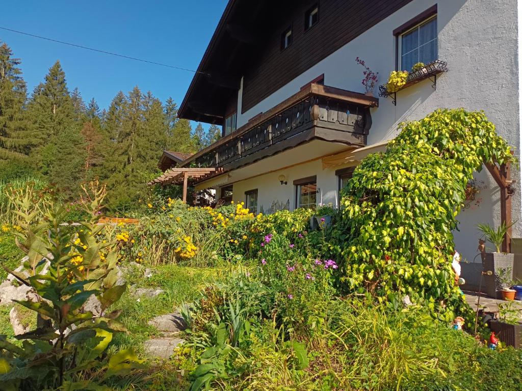 um jardim em frente a uma casa com flores em Ferienwohnung Urisee em Reutte