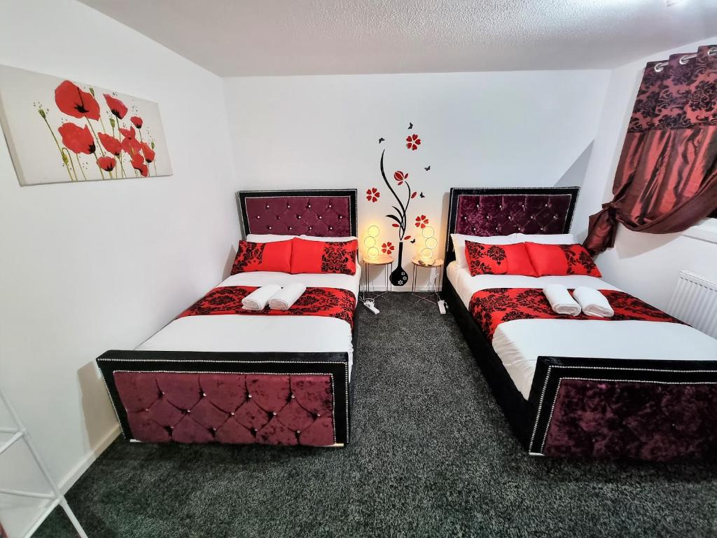 two beds in a room with red pillows at *10OR* Setup for your most relaxed & amazing stay + Free Parking + Free Fast WiFi * in Leeds
