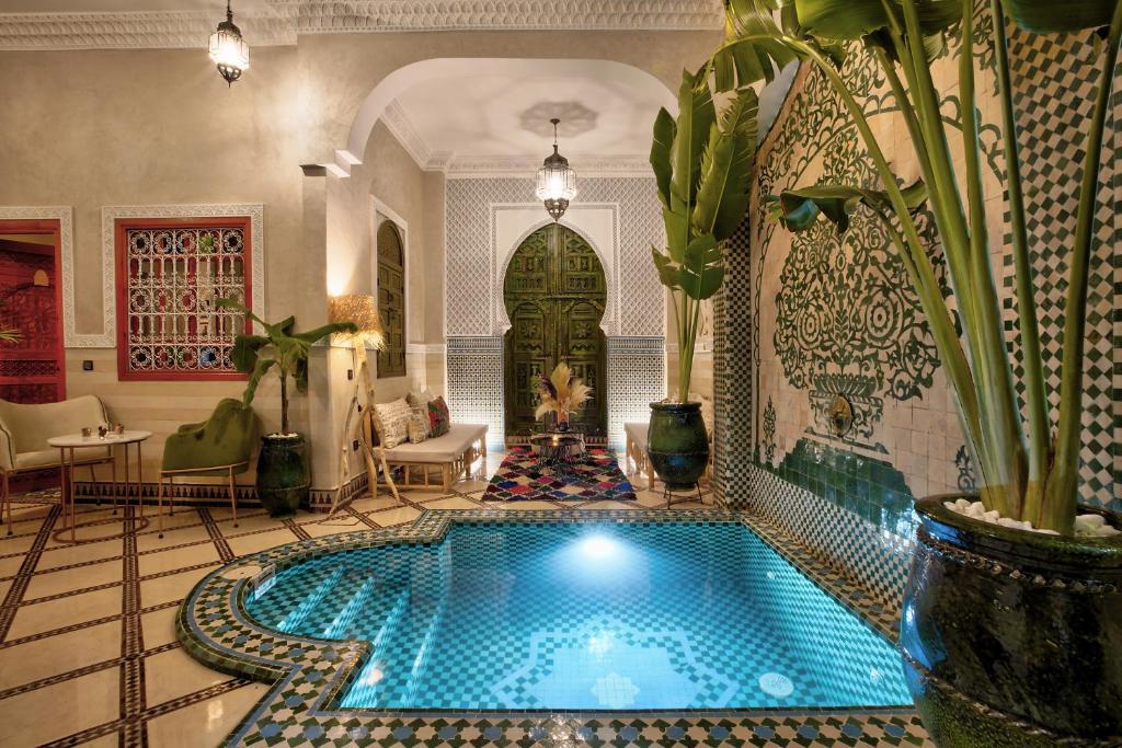 een groot zwembad in een kamer met een huis bij Riad Arabkech in Marrakesh