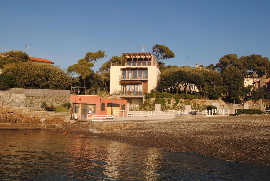 una casa sentada en la orilla de un cuerpo de agua en Villa Angolino, en Castiglioncello