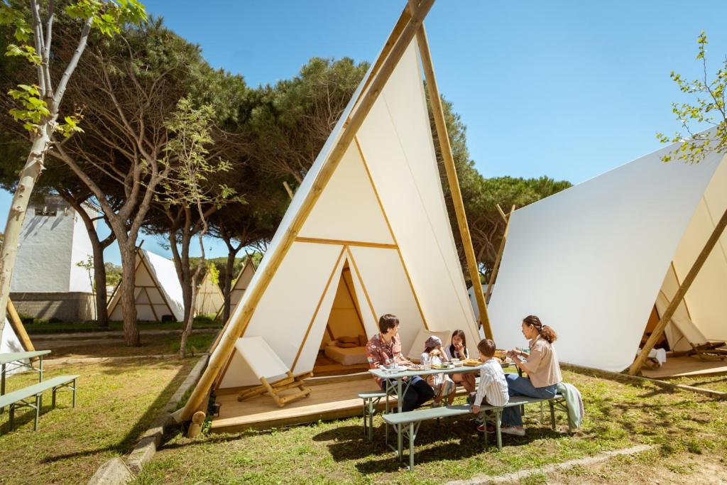 un gruppo di persone seduti a un tavolo di fronte a una tenda di Kampaoh Tarifa a Tarifa