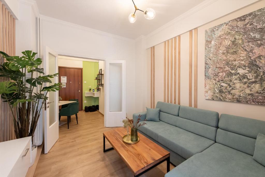 uma sala de estar com um sofá azul e uma mesa em MEDLUXE COMFORT APARTMENT em Atenas