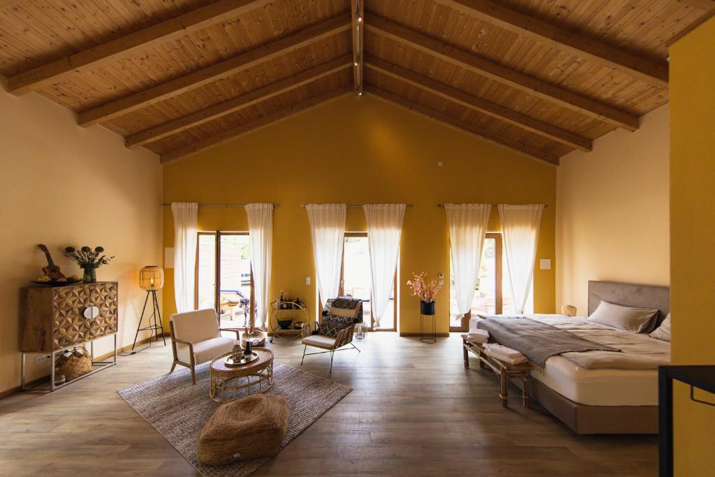 ein großes Schlafzimmer mit einem großen Bett und Stühlen in der Unterkunft Salthouse Portugal - Exclusive East Apartment in Aljezur