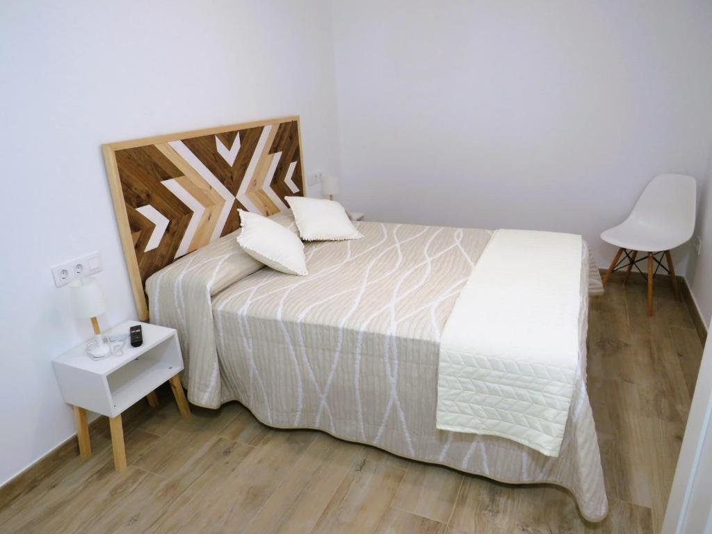 a bedroom with a large bed with a wooden headboard at Apartamento Casa Roda in Bielsa