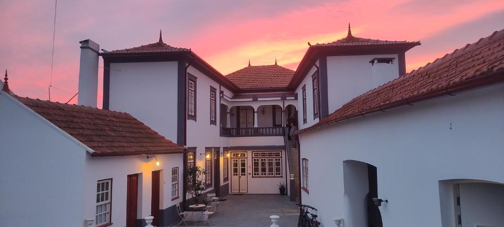 uma fila de casas brancas com um pôr-do-sol ao fundo em Casa Galricho em Murtosa