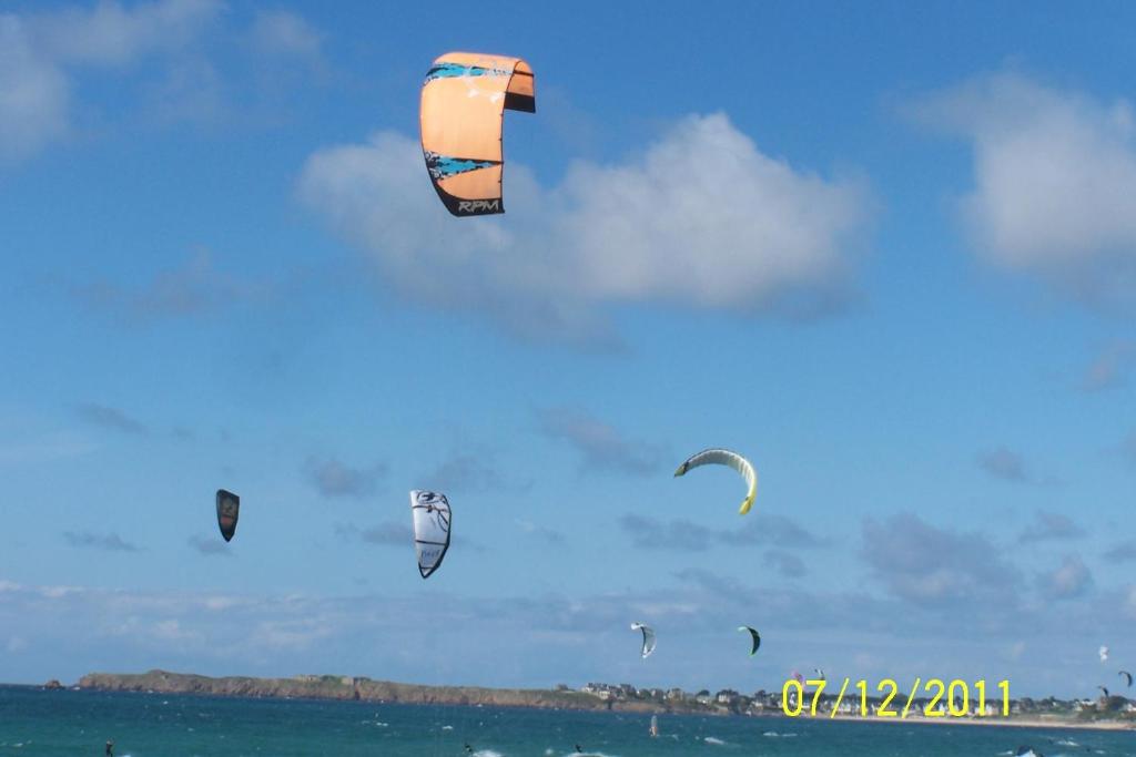 a bunch of kites flying in the sky over the ocean at Hotel De La Mer in Saint Malo