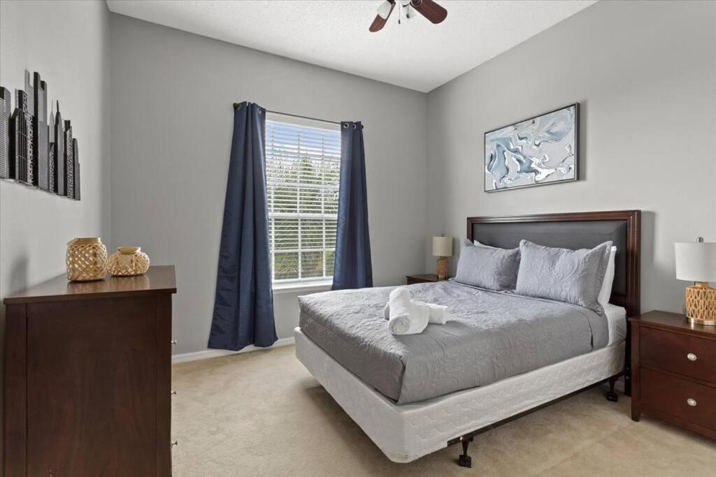 een slaapkamer met een groot bed en een raam bij LONG STAYS! Lakefront - Gated Pool Home in Orlando