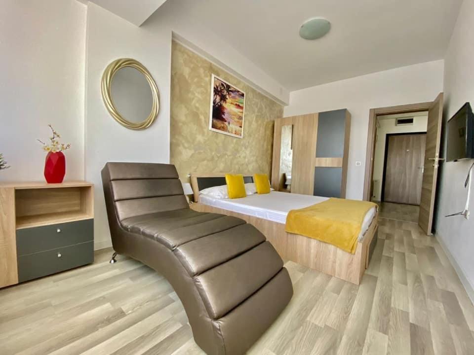 een slaapkamer met een bed en een leren stoel bij Maria Summer Apartaments in Mamaia