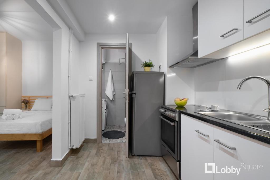 a kitchen with a refrigerator and a bed in a room at Embassy Studio by LobbySquare in Athens