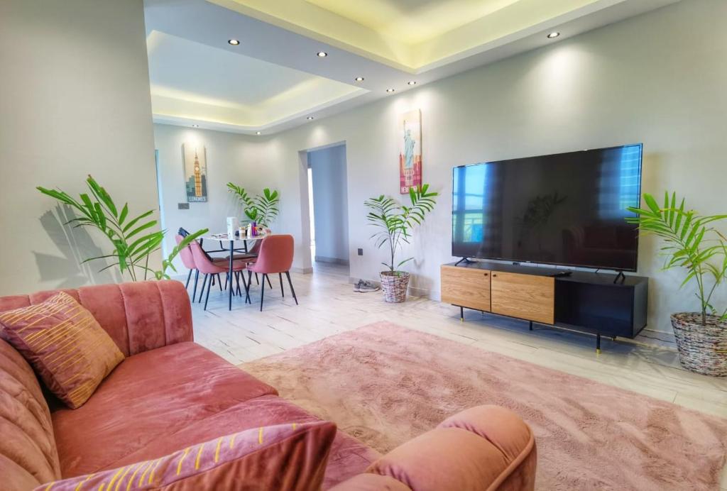 a living room with a large television and a couch at PERFECT APPART Grand Baie Centre Next To Super U, 5 Minutes from beach in Grand Baie