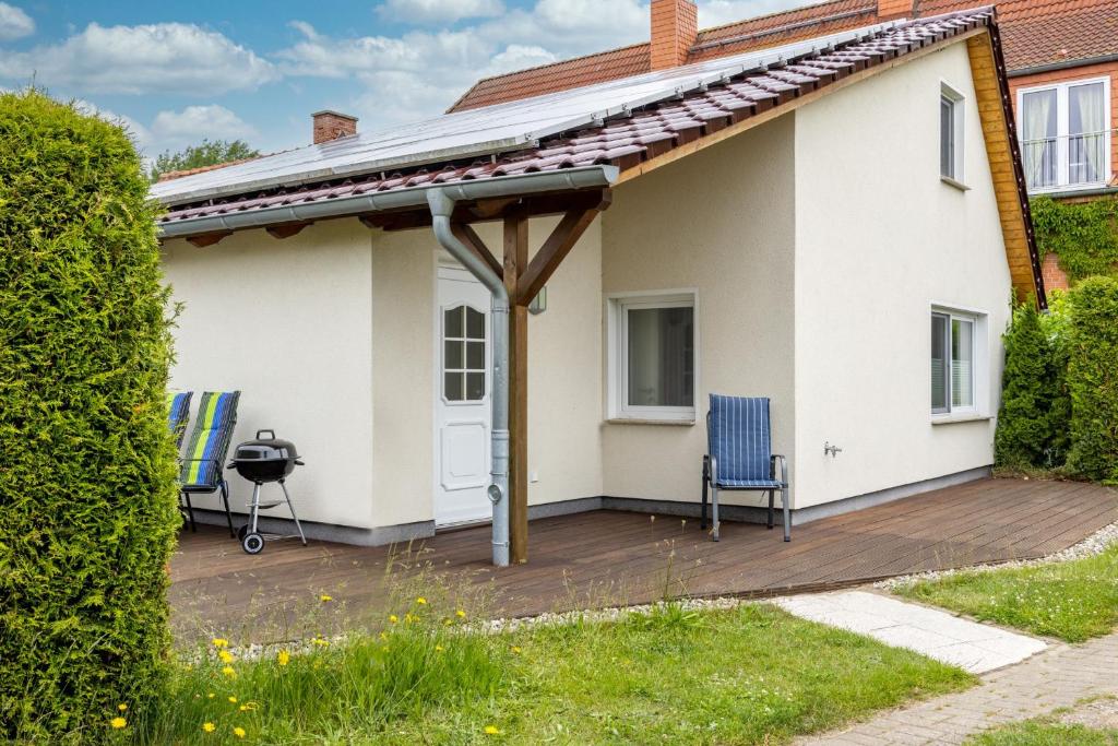 ein Haus mit einer Terrasse und 2 Stühlen in der Unterkunft Die Küstenjungs - 3 strandnahe Ferienhäuser OFC 22 in Diedrichshagen