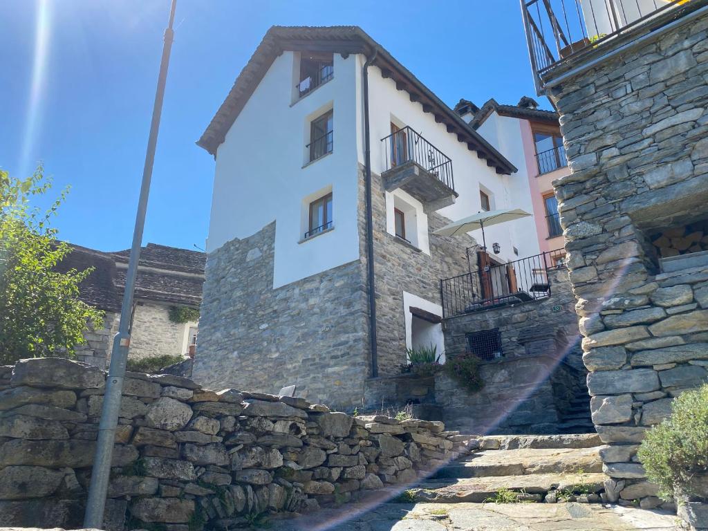 een gebouw met een stenen muur en een trap aan de voorkant bij Casa Mille Sassi in Lionza