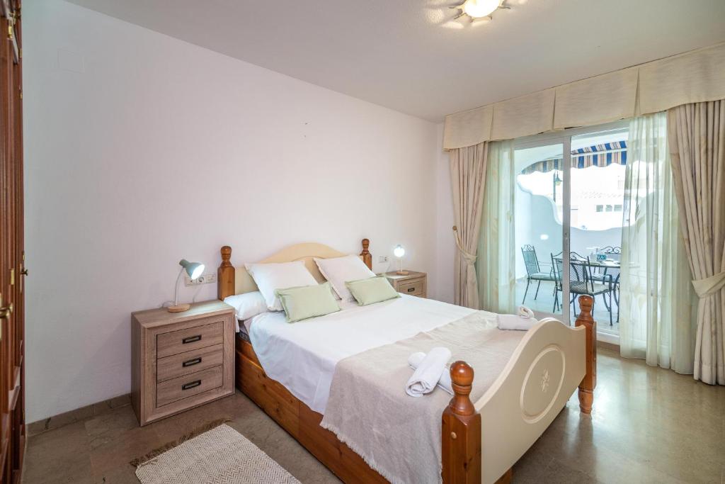 a bedroom with a large bed and a balcony at LXR Marysol II 2BDR. Apt in Benalmádena