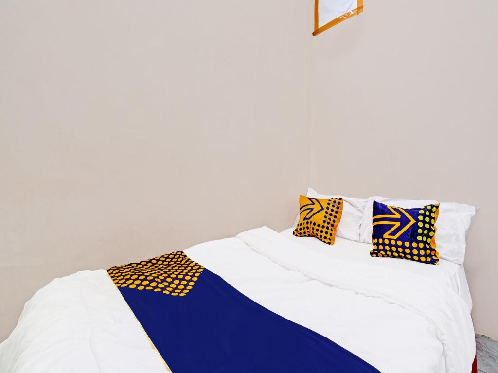 萬隆的住宿－OYO Life 91589 Bunda Homestay Syariah，白色和蓝色的床,上面有色彩缤纷的枕头